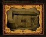 [Joel Clark standing in the doorway of his barrel-making (cooper) shop]