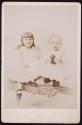 [Two children (sisters?) seated on white cast iron bench]