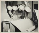 [Victor Keppler adjusting lighting for photograph of glassware]