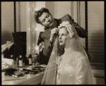 [Assistant adjusting bridal veil on model]