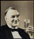 [man with monocle holding glass with ice]