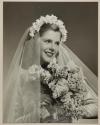 [Bride with veil, holding bouquet of flowers]