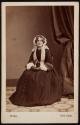 [Seated woman wearing a white bonnet]