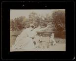 [Two women feeding cats in a yard]