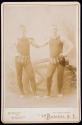 [Two male acrobats, posed in studio]