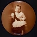 [Child in a dark sash and button-up boots]