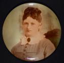 [Woman with dark brooch at collar]