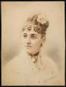 [Young woman with flower in hair]
