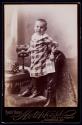 [Young boy standing on chair with stereocard and stereoviewer]