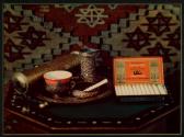 [Still life: "Senoussi" by Reemtsma cigarettes, ash tray, small coffee pot and cup, pepper mill]