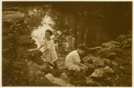 [Children on rocks by pond]
