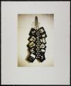 [Items in artist's studio, hanging in bunch from a hook / bungie cord]