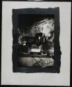 [Detail of artist's studio, items, including mask and spray paints on a table]