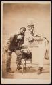 [Two men in costume, one holding a violin and the other a clock]