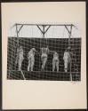 [Five trapeze artists from behind]
