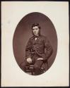 [Seated man with mutton-chop whiskers]