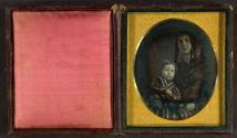 [Young mother with long curls, holding child on her lap]