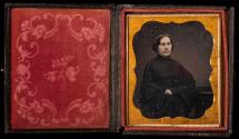 Woman wearing dark dress, draped with dark cloth