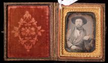 [Bearded man wearing hat and checked coat, possibly holding cigarette]