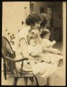 [Woman (model Ruth Malcomson) with a baby on her lap]