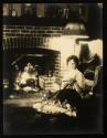 [Woman (model Ruth Malcomson) reading a letter next to a fire]