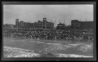 [Cabanas and people, hotels on ocean shoreline]