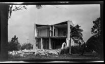 [Two story building, front wall fallen away]