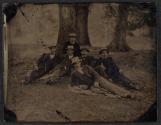 [Group of men sitting on grass]