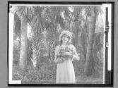 [Woman Holding Flowers In Forest]