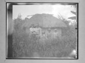 [Natives In Front Of Hut]