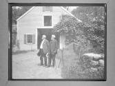 [M.W.A. and Man (Phil Allen) In Front Of Domestic Architecture]