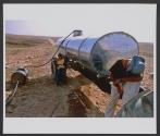 Kids from the Bedouin tribe of El Assam fill a towed tank with water, drawn illegally from an official water pipeline