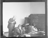 [International Conference on Photo Speed, Munich, Dr. Walter J. Clark pointing to blackboard]