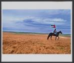 A Bedouin rides a horse, waving the Palestinian flag, during the "Land Day" protest marking the loss of Arab land to Israel, near the Bedouin city of Rahat