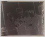[Howard A. Schumacher showing a Speed Graflex camera to three sailors]
