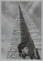 [Child placing Lego piece onto a tall Lego tower]
