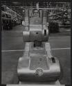 [Worker inspecting a fender deck at a John Deere manufacturing plant]