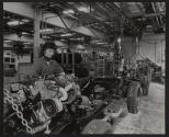 [Worker assembling engines on Jeep DJ-5 assembly line.]