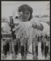 [Technician inspecting vacuum tubes in manufacturing facility]