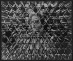 [Worker looking through a stack of metallic cylinders]