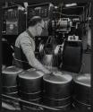 [Worker welding metal tanks]