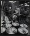 [Worker welding metal tanks]