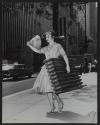 [Woman on sidewalk carrying lightweight replicas of a fire hydrant and a radiator]