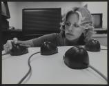 [Technician examining a mouse-like piece of electronic equipment]