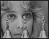 [Three small bells with cast metal figure depicting a child street singer or caroler in front of a woman's face]