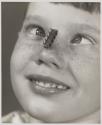 [Boy looking cross-eyed at a transistor blanced on his nose]