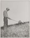 [Man teeing off using a radar dome as a golf ball]
