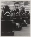 [Worker measuring objects on a manufacturing line]