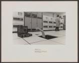 [technician reaching for tools from under a floor in a computer room]
