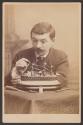 [Man constructing a model ship]